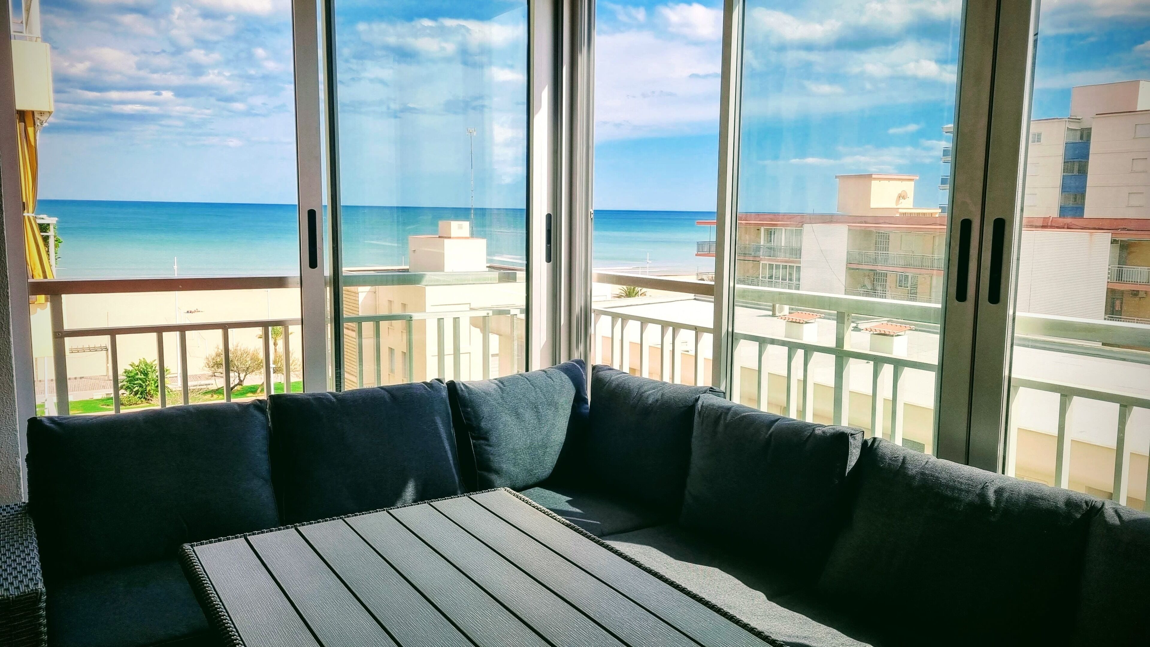 A balcony with a view of the sea and buildings.