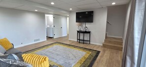 A living room with a flat-screen TV, a sofa, a coffee table, and a rug. - Luxury Lakeview Home with Panoramic Views. Sleeps 10 (Golden)
