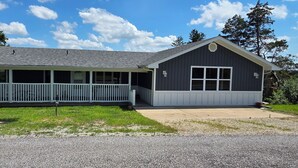 A two-story building with a covered porch and a garage. - Luxury Lakeview Home with Panoramic Views. Sleeps 10 (Golden)