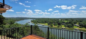 A balcony with a view of a river, boats, and surrounding greenery. - Luxury Lakeview Home with Panoramic Views. Sleeps 10 (Golden)