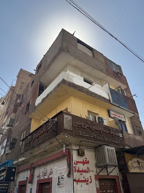 A multi-story building with various signs and advertisements, including a pharmacy and a bank.