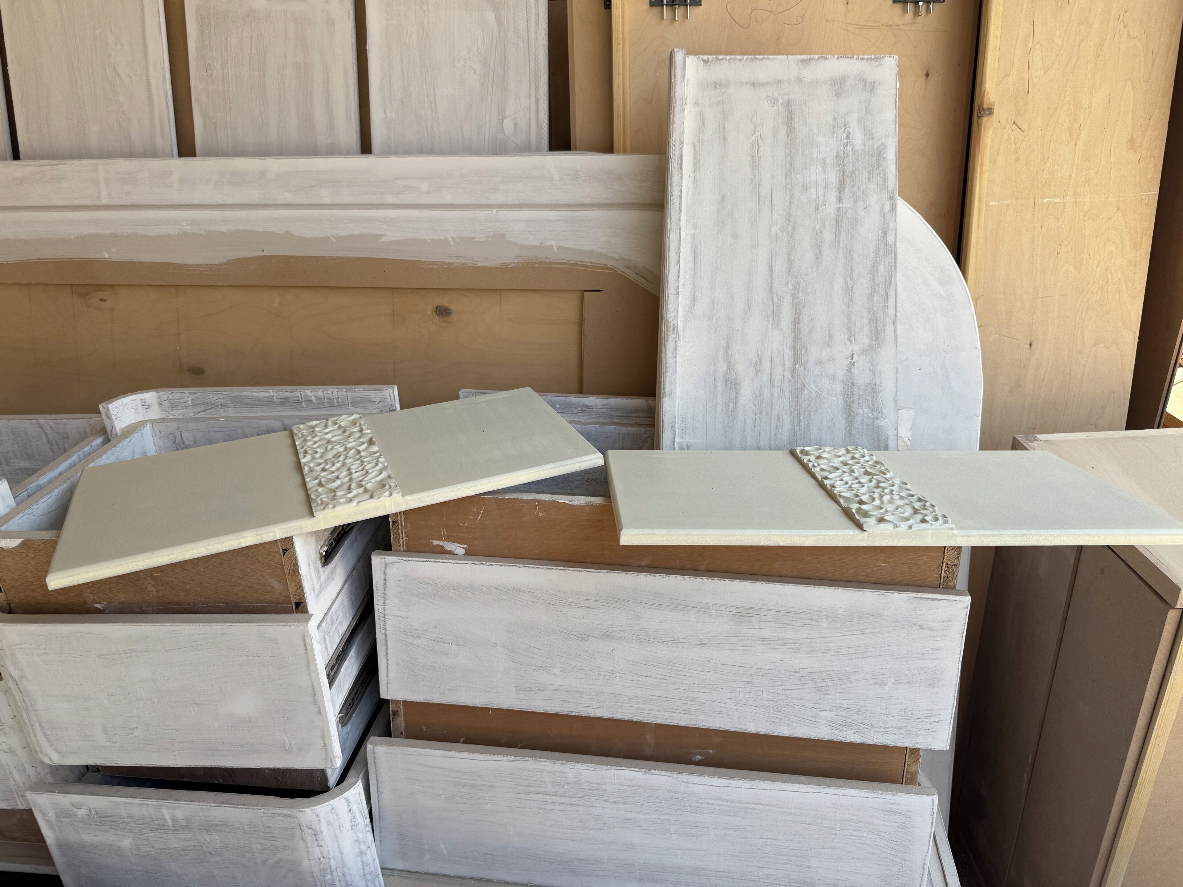 Des piles de panneaux en bois blanc aux bords texturés, probablement utilisés pour la construction ou la décoration intérieure.