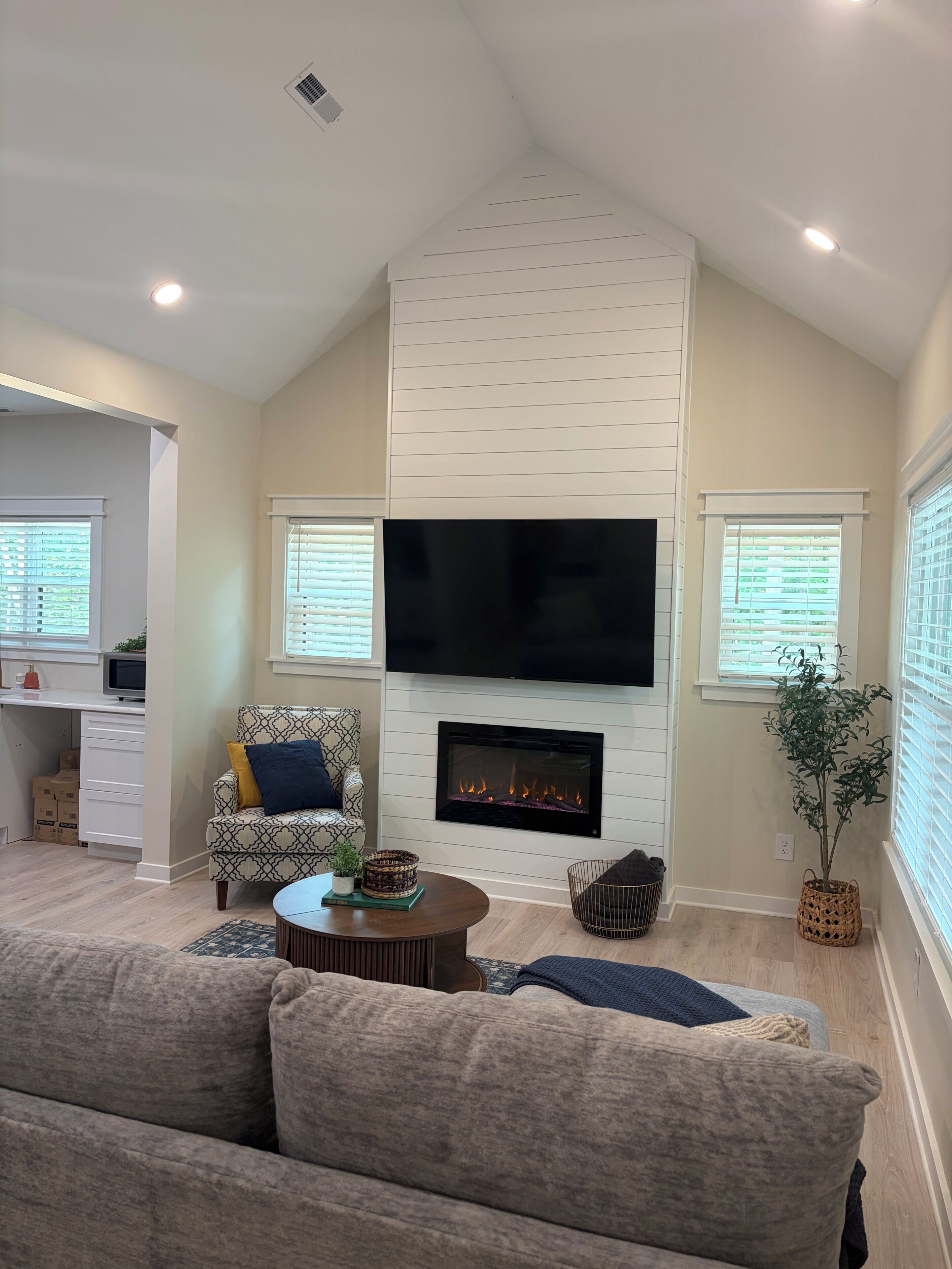 A living room with a fireplace, a flat-screen TV, a sofa, and a coffee table.