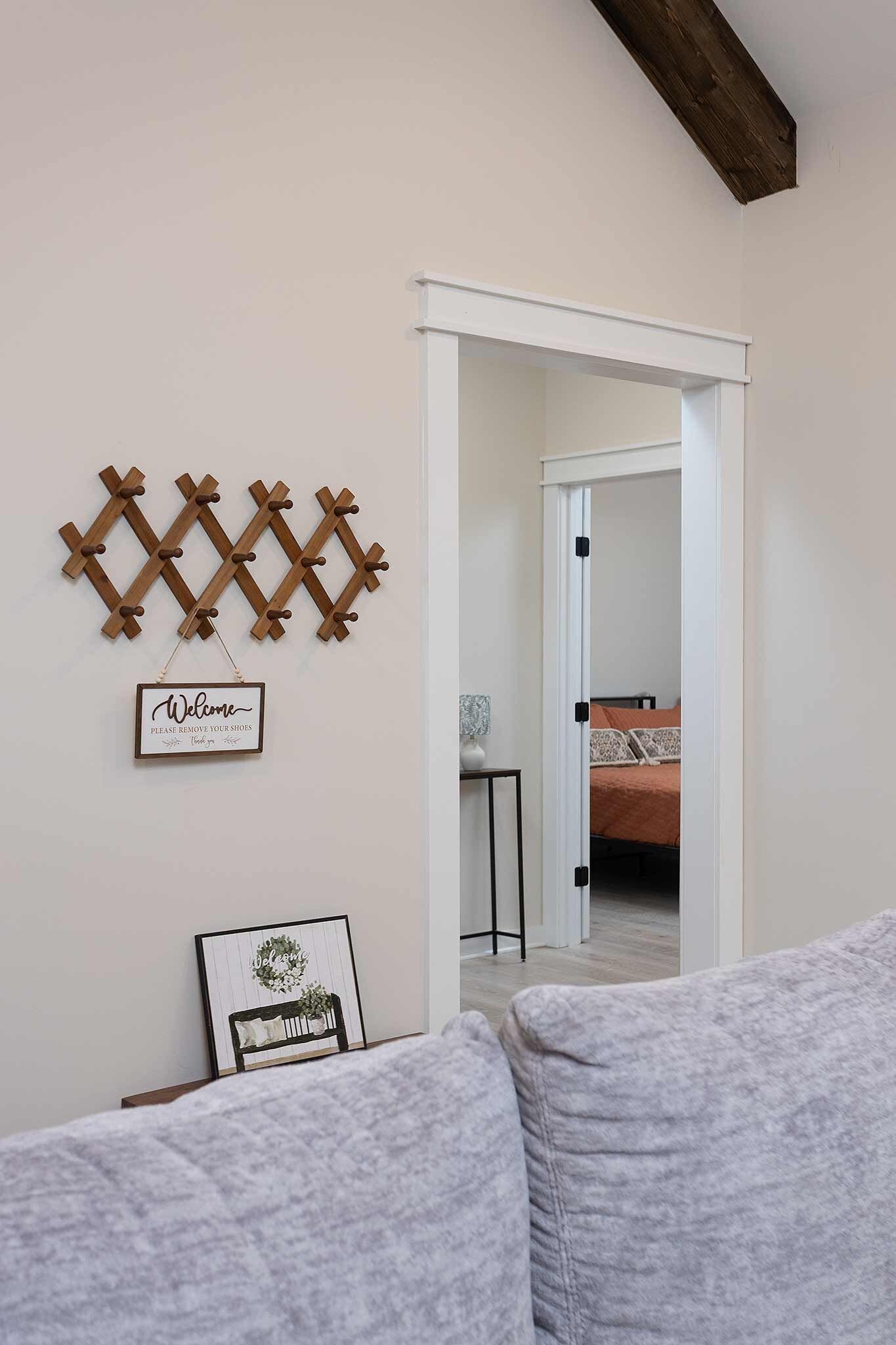 Een kamer met een wanddecoratie van houten latten, een welkomstbord en een ingelijst schilderij.