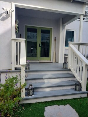 A house with a green door, white railings, and steps leading to a porch. - Venice Canals Beach House (Los Angeles)