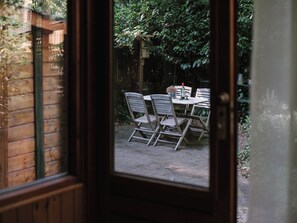 A wooden door with a view of an outdoor patio area. - A cozy chalet nestled among the tall trees and birds. Pet-friendly! Great location! (Lanaken)