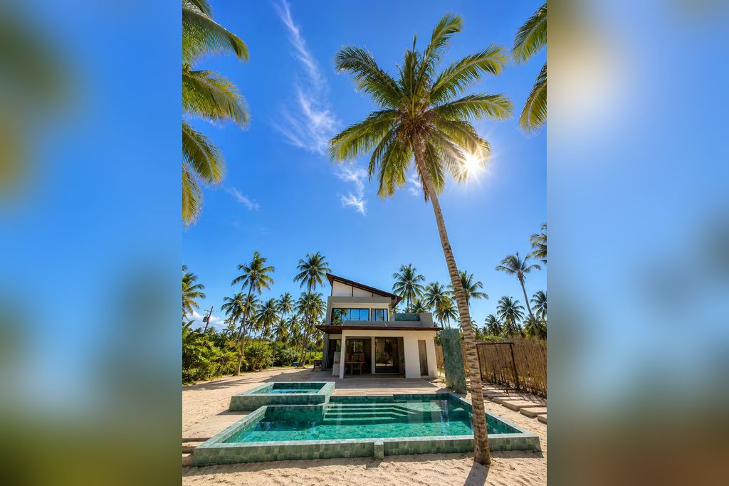 A modern house with a pool and palm trees.