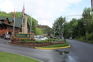 Schild des Westgate Smoky Mountain Resort mit einem Steinturm, umgeben von Blumenbeeten und parkenden Autos.