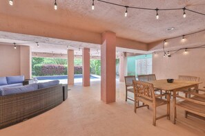 Eine Außenpatio mit Pool, Sitzbereich und Esstisch.