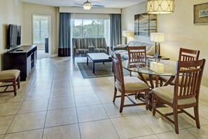 A hotel room with a dining area, a sofa, a TV, and a ceiling fan. - Cozy 2-bedroom condo with AC in lovely Clermont (Clermont)