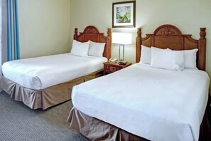 A hotel room with two single beds, each with a wooden headboard, a bedside table with a lamp, and a framed picture on the wall. - Cozy 2-bedroom condo with AC in lovely Clermont (Clermont)