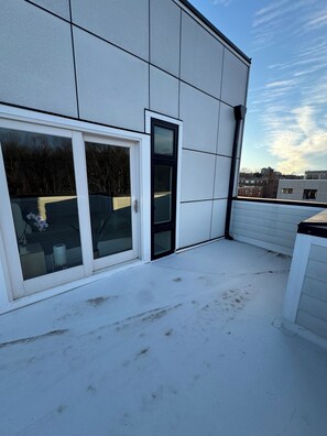 Fachada de un edificio moderno con un gran ventanal de vidrio, techo plano y cielo despejado.