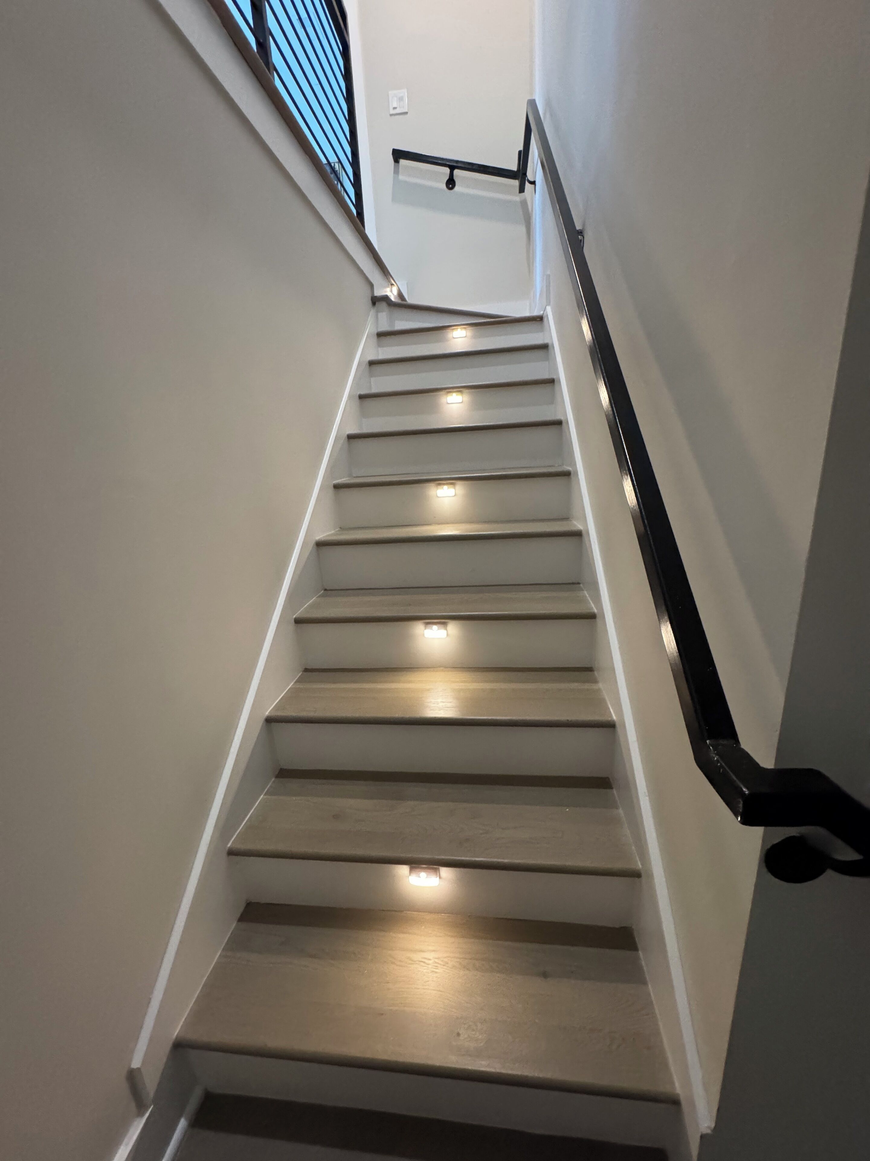 A staircase with handrails and lighting fixtures.