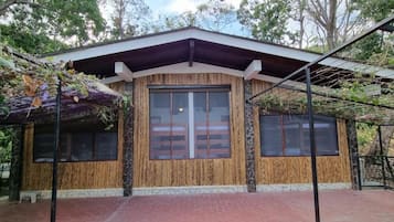 A building with a large central window, smaller side windows, and a sloped roof.