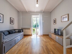 A modern living room with a sofa, a TV, and a staircase. - Lunariae by Interhome (Rosignano Monferrato)