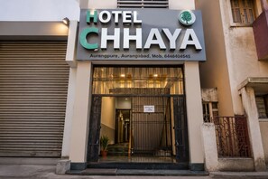 Entrada de un hotel con un cartel que dice 'HOTEL CHHAYA' y un letrero de salida que indica las 11:00 AM.