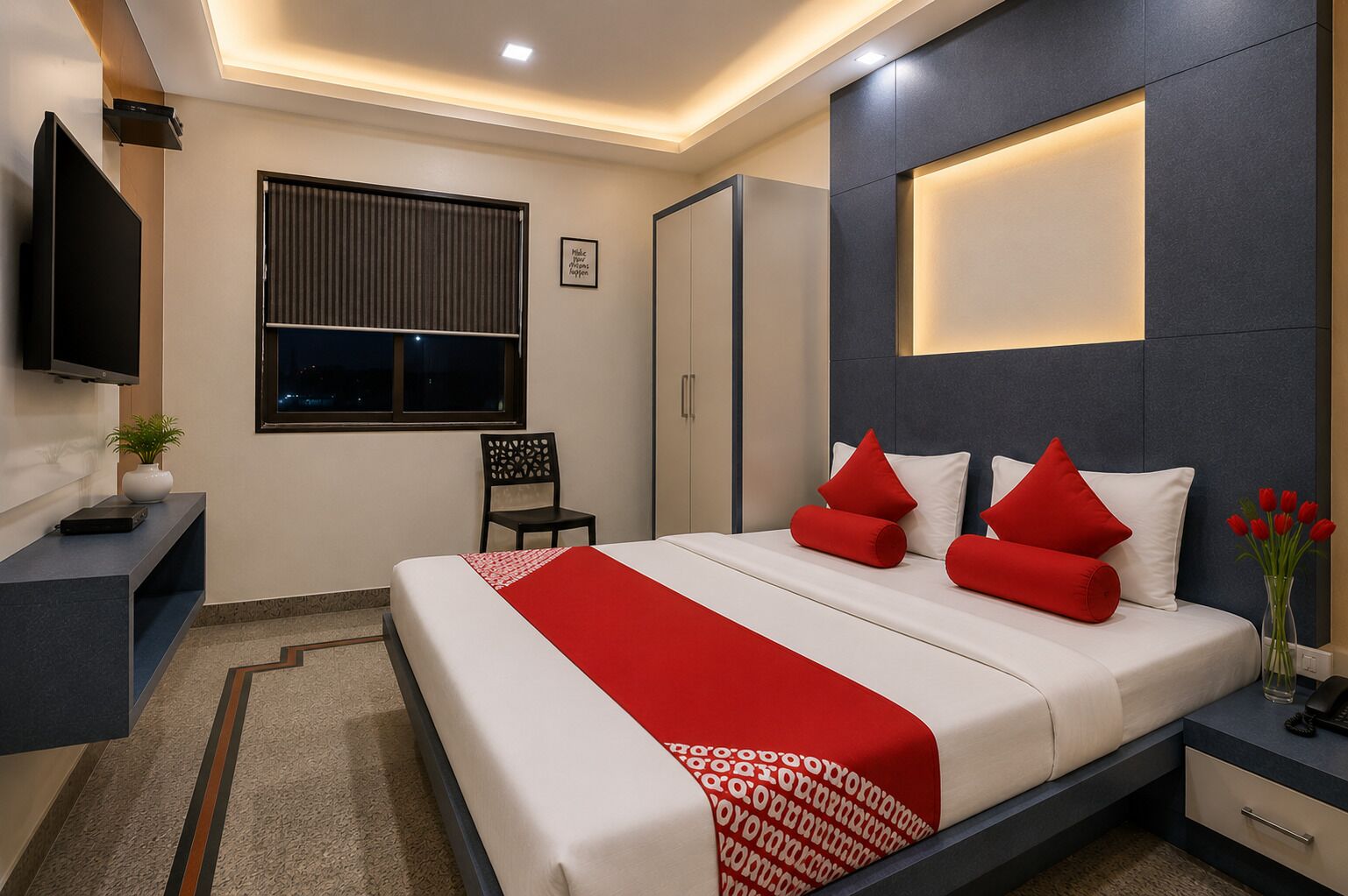Una habitación de hotel moderna con una cama, mesita de noche, televisor y ventana con persianas.