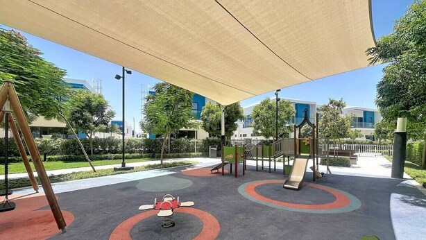 Zona de juegos al aire libre con columpios, toboganes y una estructura para escalar.