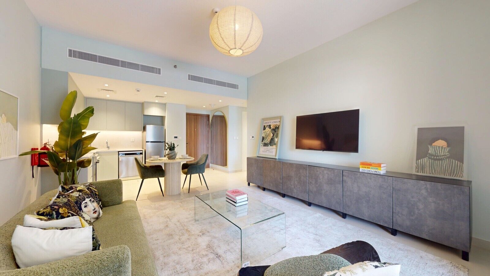 Un salon moderne avec un canapé, une table basse et un téléviseur fixé au mur.
