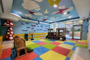 A children's play area with a colorful floor, a playhouse, and a wall with alphabet-themed decorations. - Elevated 1 Bed on 34th Floor l City View l Marina (Dubai Marina)