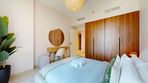 Un dormitorio moderno con cama, escritorio, silla, planta en maceta y armario.