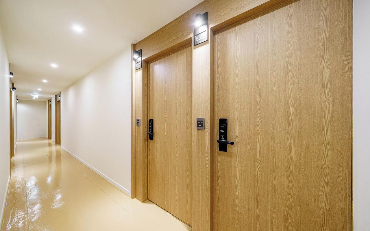 A hallway with wooden doors, each marked with a number.