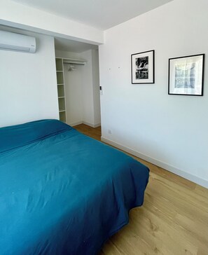 A bedroom with a bed, a closet, and two framed pictures on the wall. - BY THE WATER'S EDGE (Frontignan)