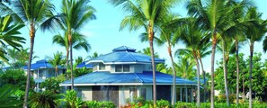 Ein Resort mit mehreren Gebäuden, Palmen und blauem Himmel.