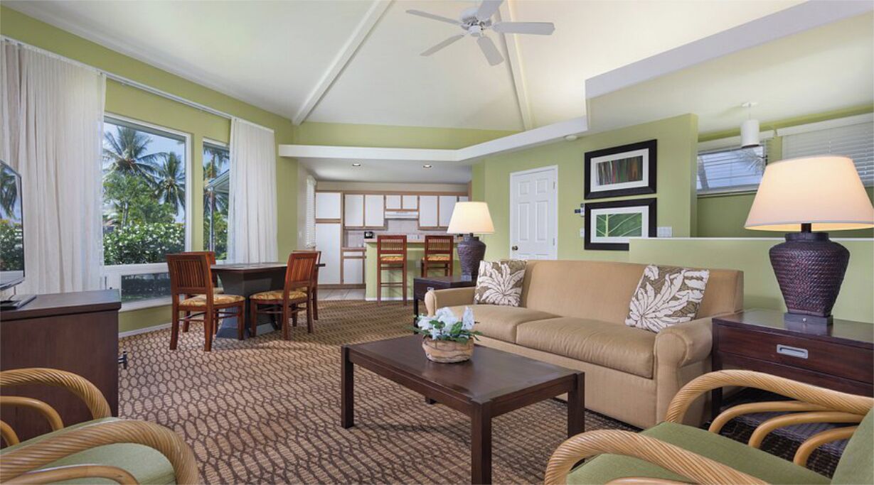A living room with a sofa, chairs, a coffee table, and a television.
