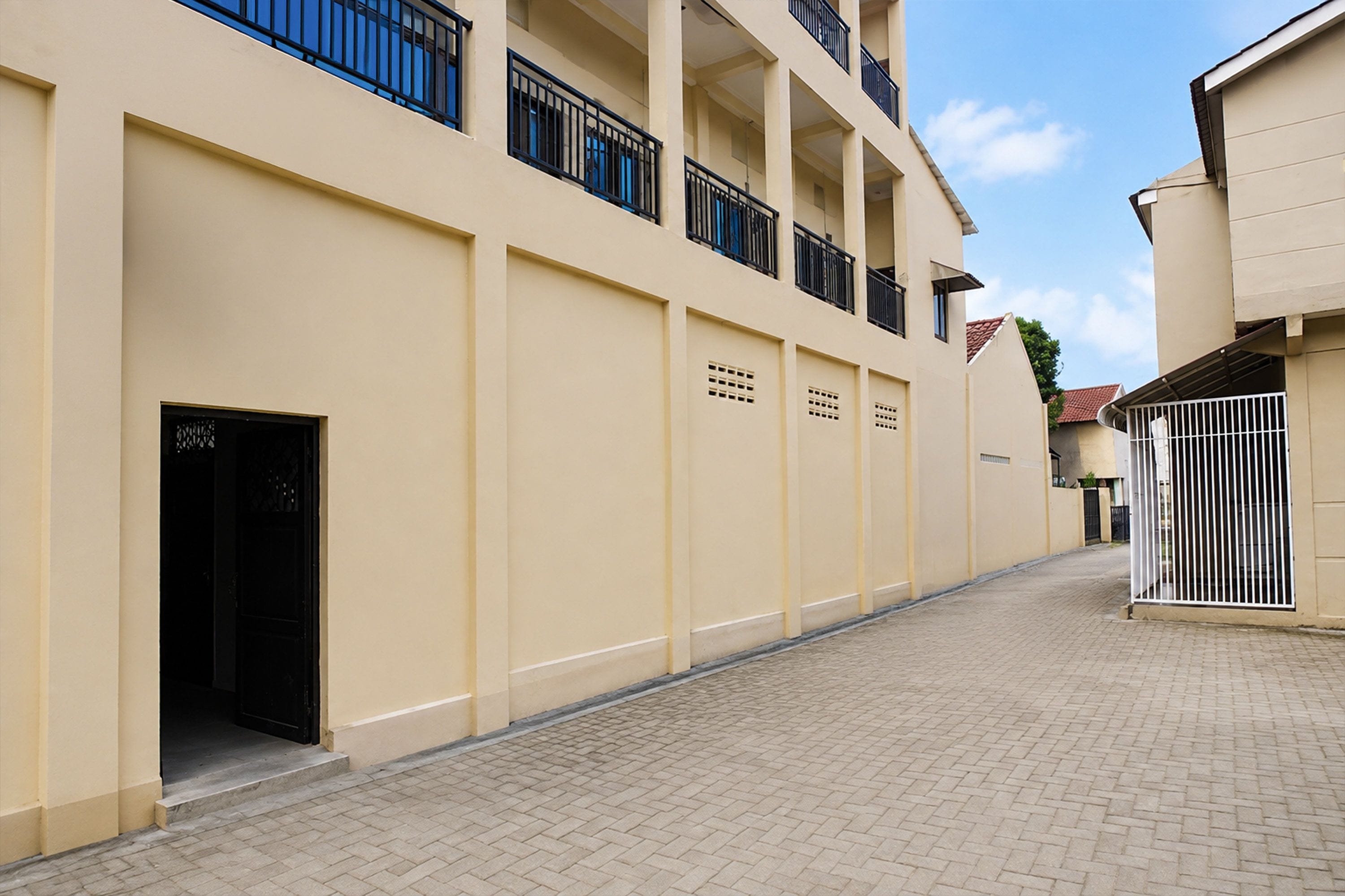Um edifício residencial com vários andares e um pátio pavimentado.