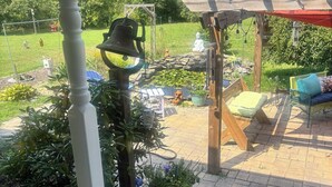 En velanlagt gårdhave med pergola, siddepladser og krukker med planter.