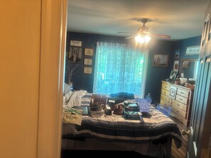 A bedroom with a bed, dresser, and a ceiling fan. - Tranquil country retreat: Relax, Unwind & Recharge” (Delmar)