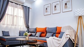 Una sala de estar moderna con un sofá, una mesa de centro y una lámpara de pie.