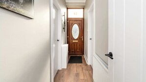 A hallway with a wooden door, white walls, and a black doormat. - Spacious Inverurie Stay -Nr Train Station -Parking (Aberdeenshire)