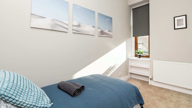 A bedroom with a bed, a window with a view, and wall art. - Spacious Inverurie Stay -Nr Train Station -Parking (Aberdeenshire)