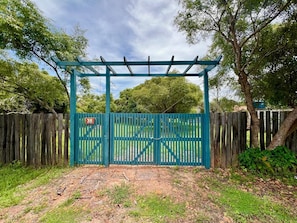 A gated entrance with a wooden fence and a blue gate. - #2 Rosário Marajó Residence - Água Boa - Two Suites (Salvaterra)