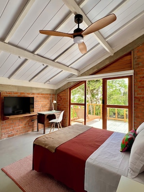 A bedroom with a TV, desk, and large windows. - Vrbo Property (Salvaterra)