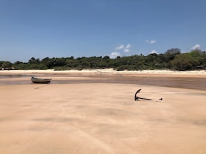 A sandy beach with a boat and a bird on the sand. - #2 Rosário Marajó Residence - Água Boa - Two Suites (Salvaterra)
