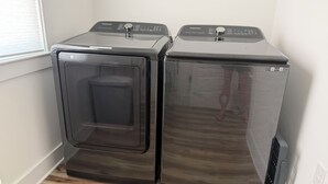 Dos lavadoras de carga frontal en una esquina, cerca de una ventana y una puerta.