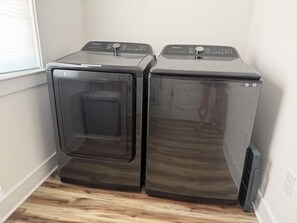 Two front-loading washing machines in a corner with a window and a door. - Paradise Beach on Perdido Bay• Dog Friendly (Pensacola)
