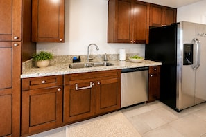 A kitchen with wooden cabinets, stainless steel appliances, a granite countertop, and a built-in dishwasher. - Aloha Scottsdale, Poolside Old Town Retreat (Scottsdale)