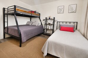 A bunk bed room with a desk and chair, a small shelf, and two framed pictures on the wall. - Aloha Scottsdale, Poolside Old Town Retreat (Scottsdale)