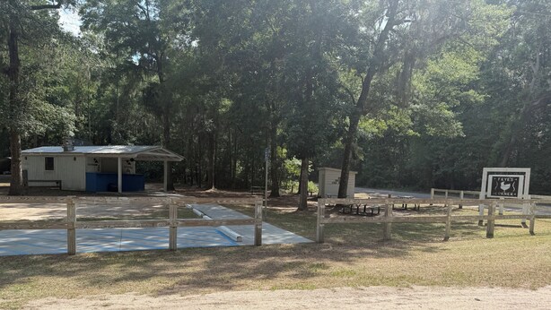 A campground with picnic tables, a covered shelter, and a sign for Frye's Corner. - Nonna's Cottage,Spacious 3-bedroom Stand alone house,cart and landtrans included (Daufuskie Island)