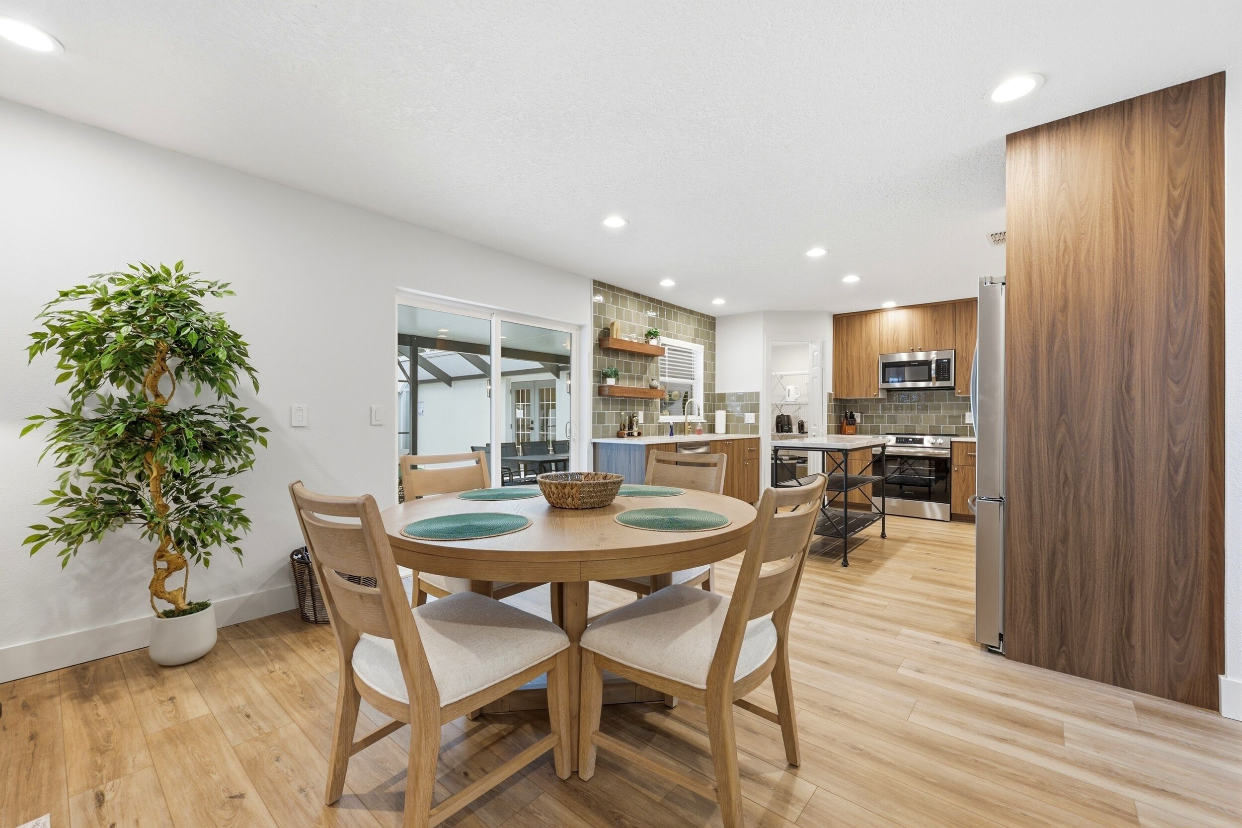 Une cuisine moderne avec des meubles en bois, un four encastré et un four à micro-ondes.