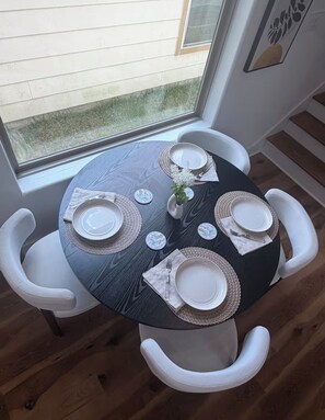 A round dining table with white chairs, set with plates, cutlery, and a small vase with flowers. - Modern Home Near Houston Heights/Airport/Downtown

2 Miles from Best Night Life (Houston)