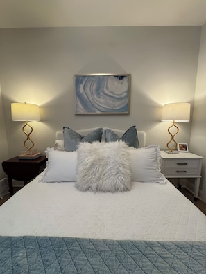 A neatly made bed with a white duvet, fluffy pillows, and a blue quilted bedspread. - Old Oaks Oasis: 3-bedroom house in welcoming Oxford (Oxford)