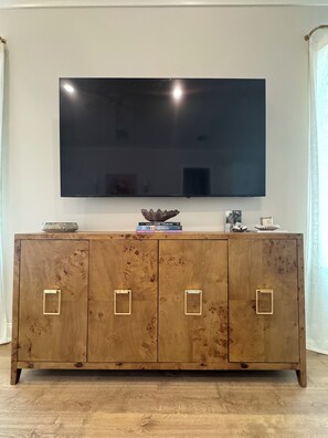 A wooden cabinet with a flat-screen TV mounted above it. - Old Oaks Oasis: 3-bedroom house in welcoming Oxford (Oxford)