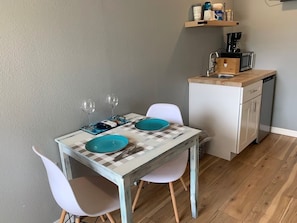 A small dining area with a table set for two, a microwave, and a coffee maker on the counter. - Enjoyable studio with AC in charming Lutz 20 miles from Airport (Lutz)