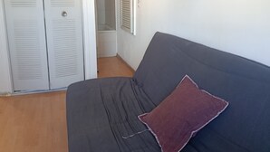 Ett sovrum med en säng, en garderob och en duschhörna.