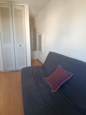 Ein Schlafzimmer mit Bett, Kleiderschrank und einer Duschkabine.
